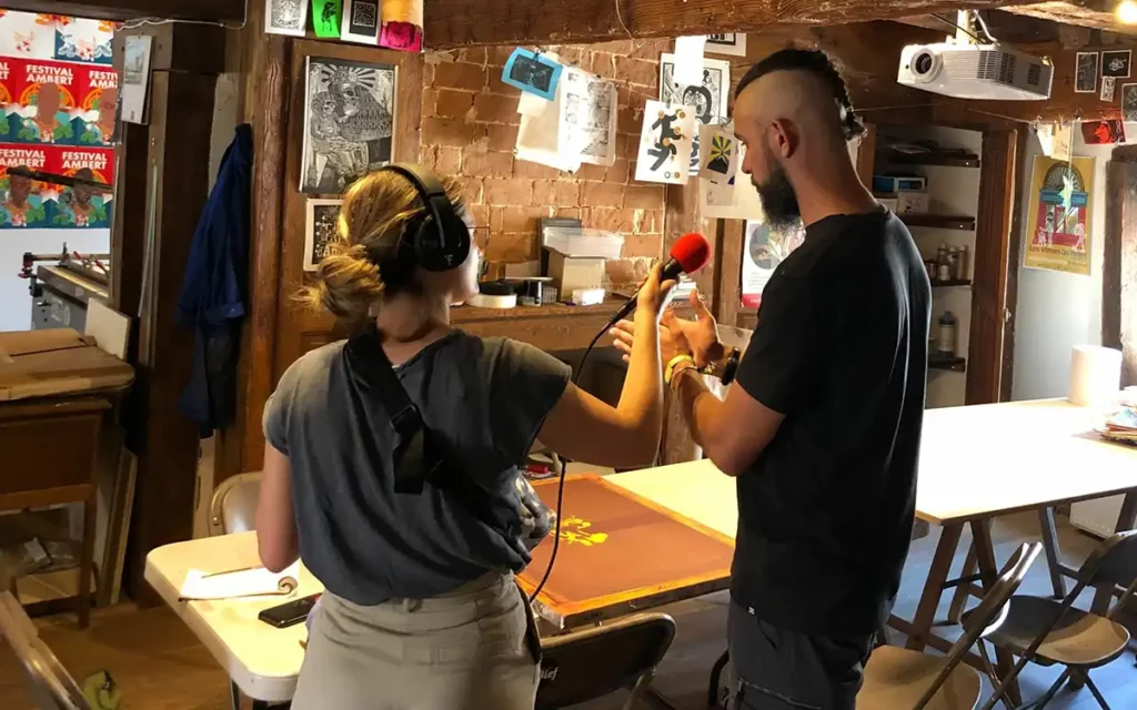 Ben est interviewé par une animatrice de Galoche de dos dans le local du pôle Arts Graphiques du centre culturel Le Bief.
